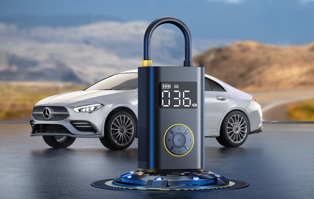 Portable compressor with display. A silver Mercedes is visible behind it.