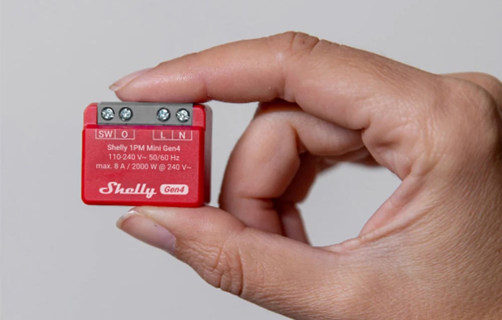 A small, red controller held between two fingers.