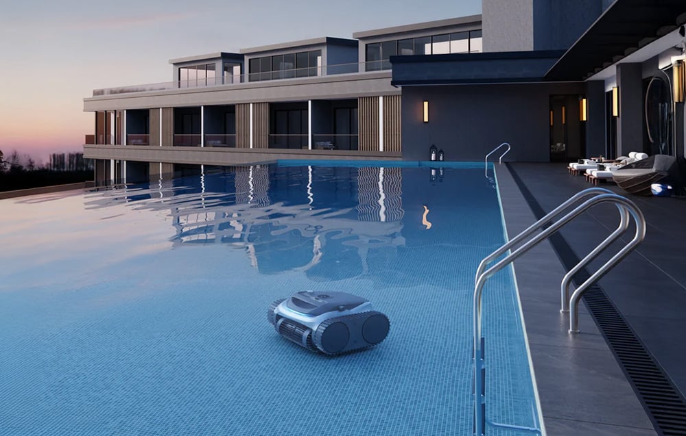 Pool robot cleaning the bottom of a large pool next to a building
