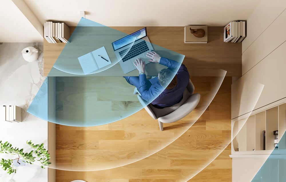 The smart sensor detects the presence of a man sitting at a desk