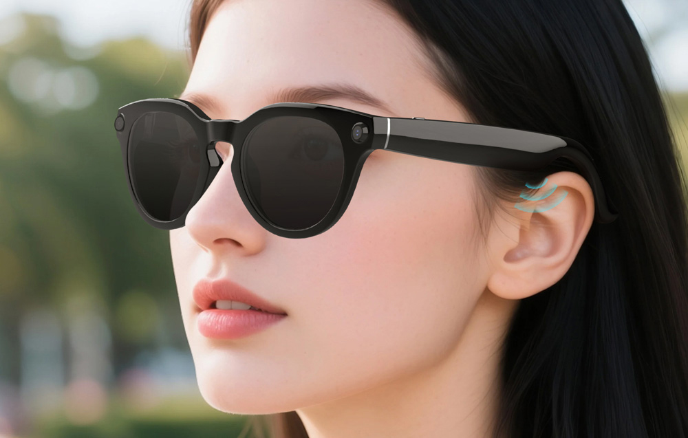 Profile of a woman wearing black smart glasses; the graphic highlights the built-in speakers with blue sound waves near the ear.