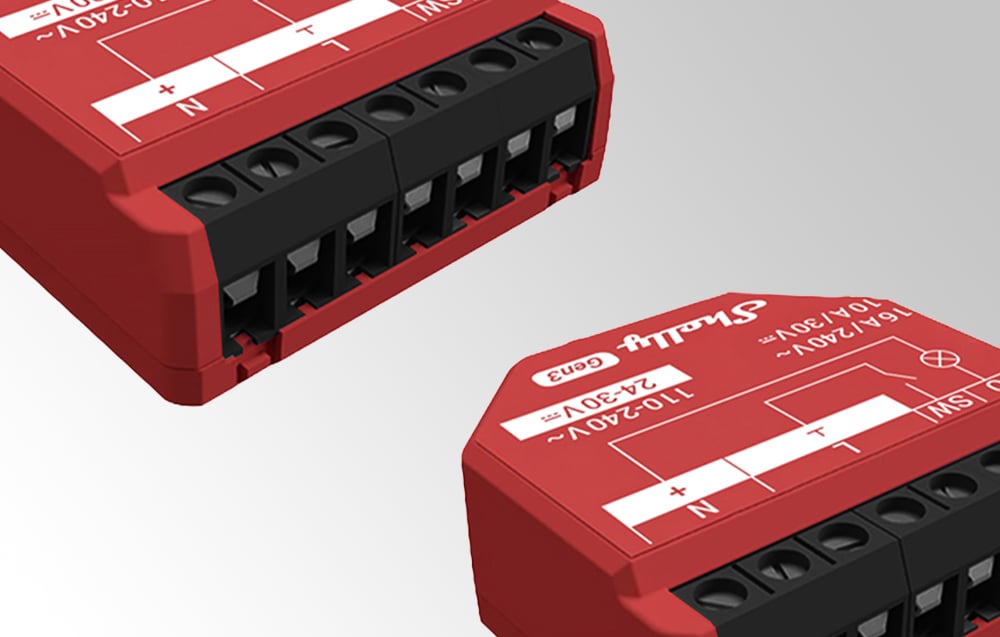 Two red Shelly 1PM Gen3 modules shown from an angle on a gray background, showing connectors and printing