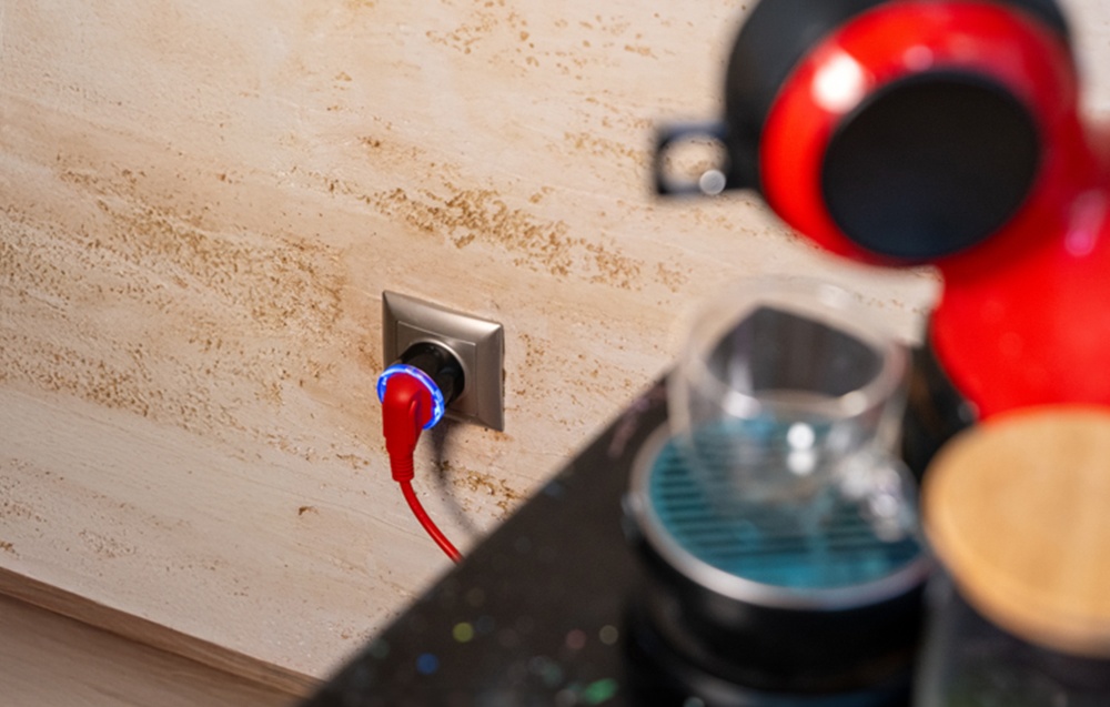 Coffee maker next to Shelly Plug S with blue backlight and red wire