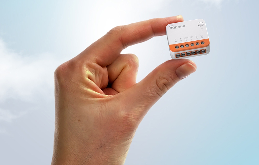 A small Sonoff switch held in the hand