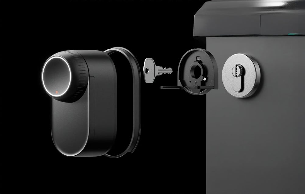 SwitchBot lock assembly diagram showing the body, key, cylinder and outer escutcheon on a black background