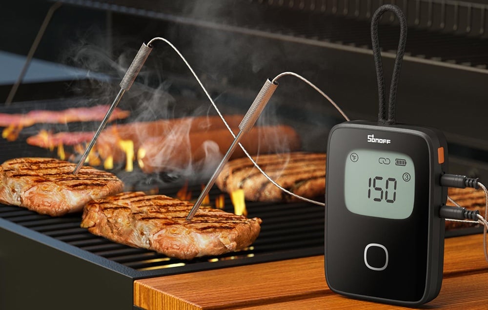 Two SONOFF MPS01 probes measuring the temperature of grilled meat, on the right is a thermometer displaying the temperature.