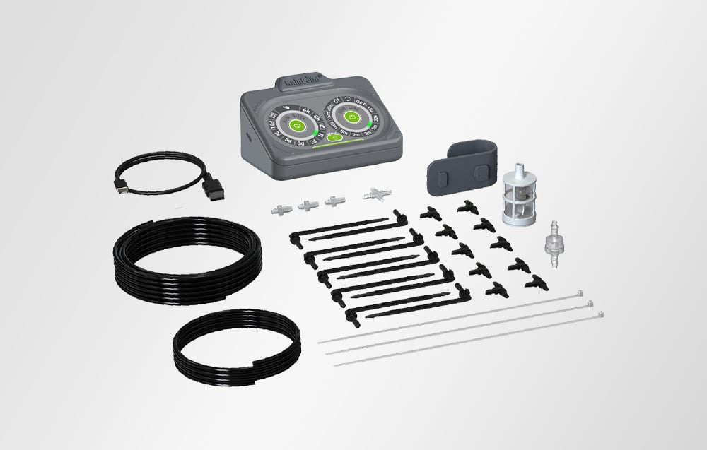 Irrigation kit containing a RainPoint® controller, two rolls of black tubing, a USB cable, filters, T-connectors, and mounting pins on a white background