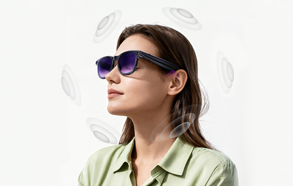 A woman in a green shirt with a visualization of sound waves spreading around her smart glasses