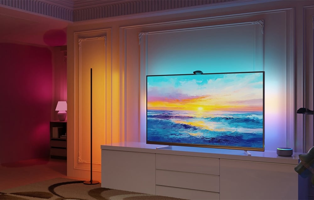 Bright living room with a large TV and a white dresser, illuminated in colorful lights