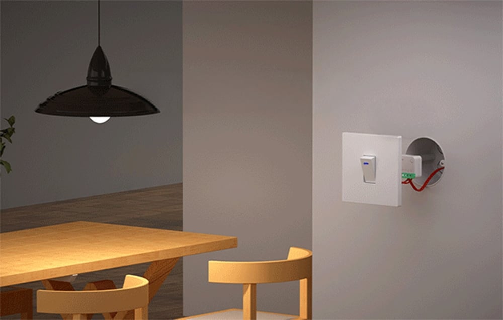 The switch in a mounting box next to the light switch; to the left, a table with chairs and a lamp