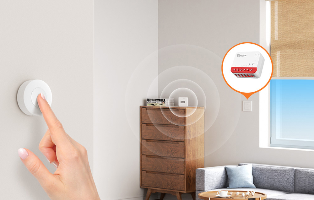 A hand pressing a white wall button with a SONOFF module visible in the background of the living room with a sofa and dresser