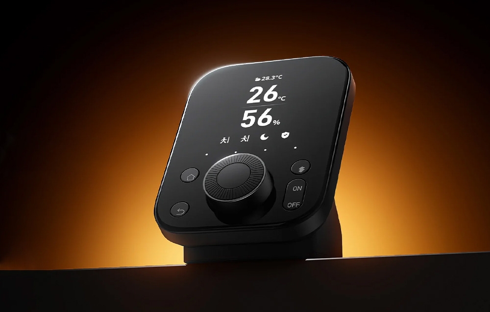 Black SwitchBot Hub 2 remote control with 26°C temperature and 56% humidity display on stand