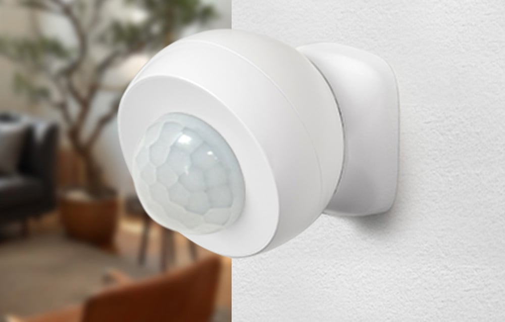 Close-up of the white motion sensor mounted on the wall in the home interior