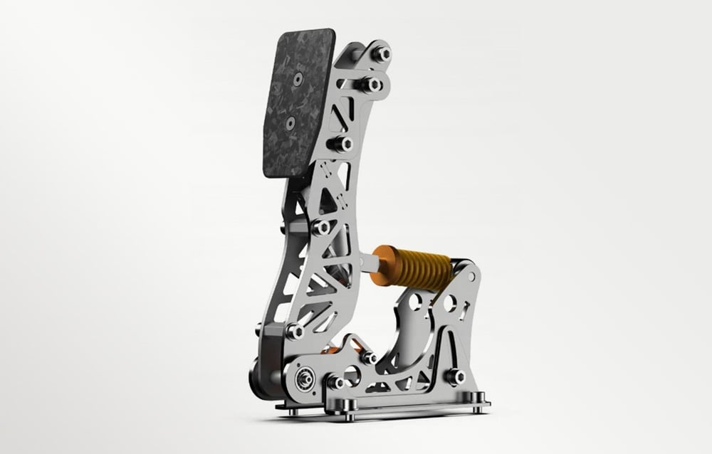 A silver PXN sim racing pedal with a carbon fiber texture and an orange-and-yellow shock absorber, side view
