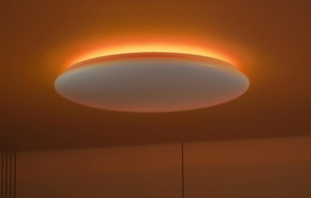 Lampa sufitowa świecąca na pomarańczowo w ciemnym pomieszczeniu.