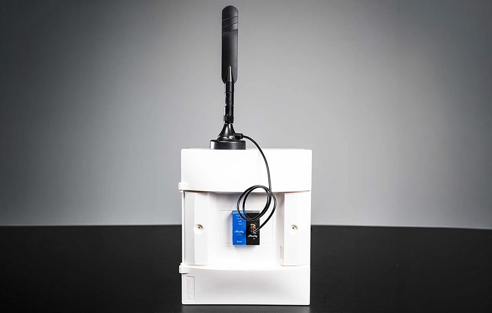 Shelly modules connected to a white box with a black antenna against a gray background