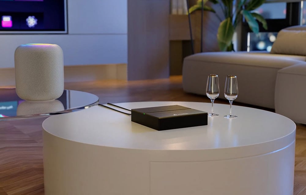 Matter device on a round table in a modern living room, next to two glasses and a smart speaker