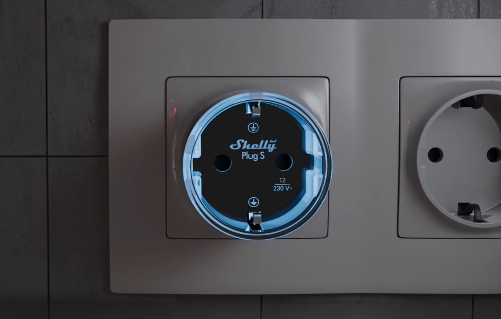 Shelly Plug S smart plug with blue illumination plugged into a wall outlet