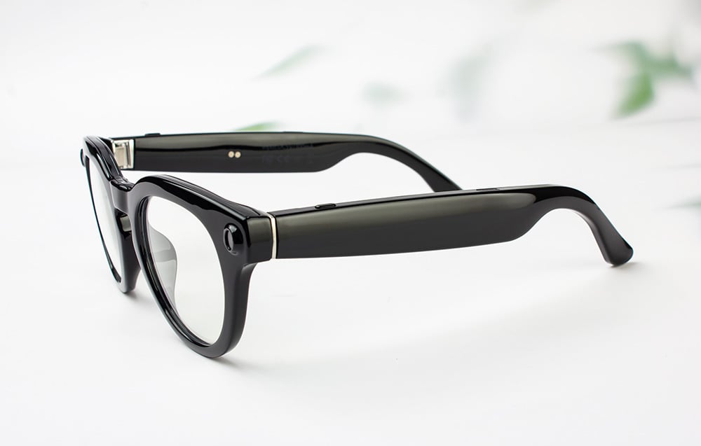 Product photo of black smart glasses in profile, showing wide temples with electronics.