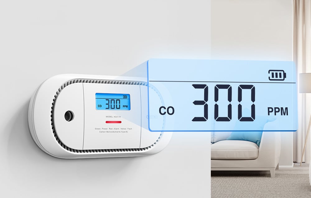 Biały detektor CO na ścianie z powiększonym wyświetlaczem 300 PPM na tle salonu