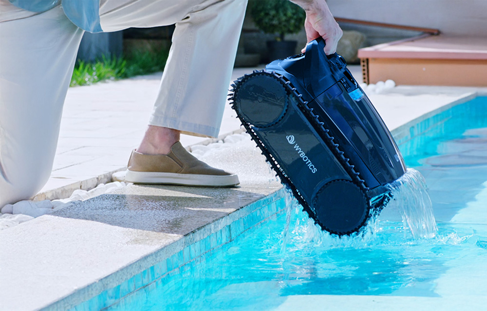 Person removing WYBOT robot from pool