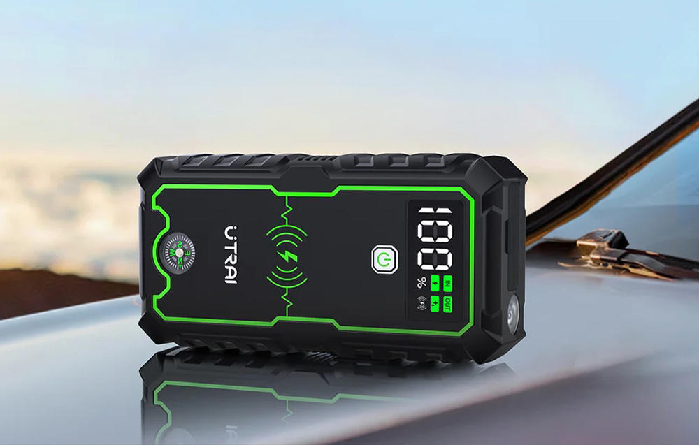 A multifunctional device with a compass and a screen lying on the hood of a passenger car.