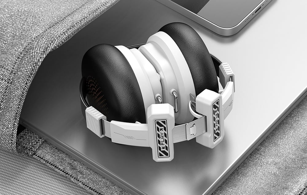Folded gaming headphones being placed in a bag with a laptop and tablet