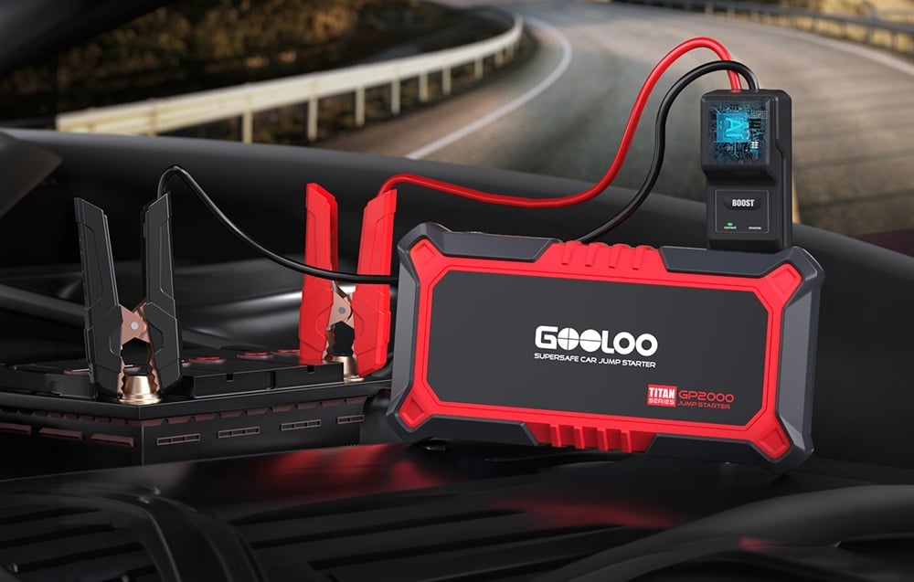 Car jump starter connected to the battery in the engine compartment