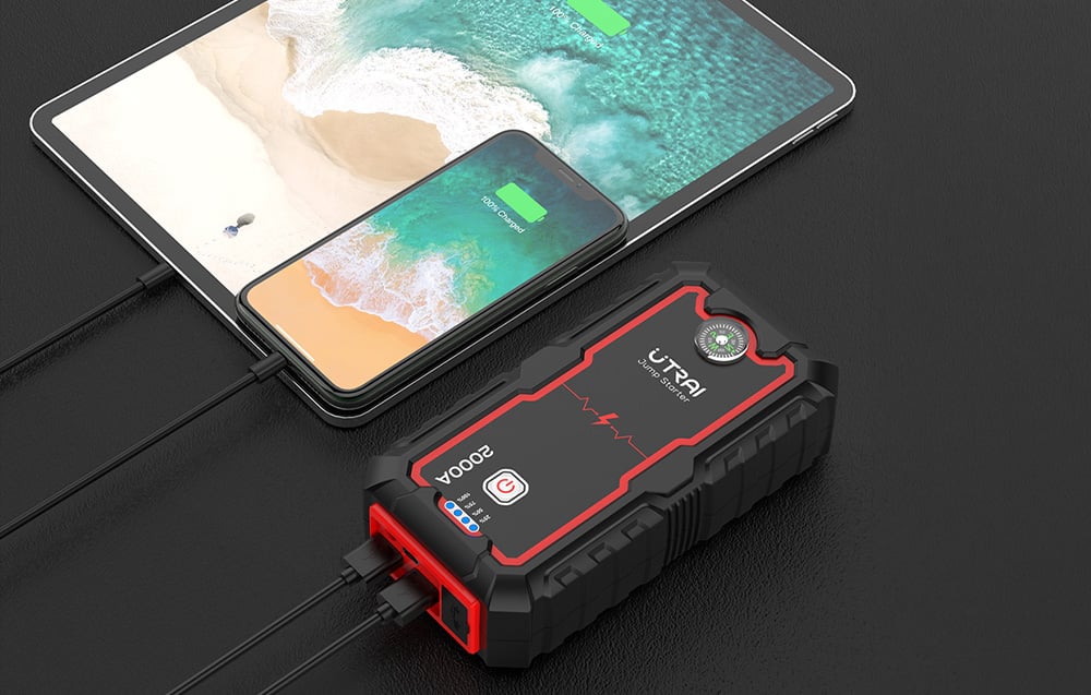 The Utrai jump starter functioning as a power bank, charging a connected smartphone and tablet.