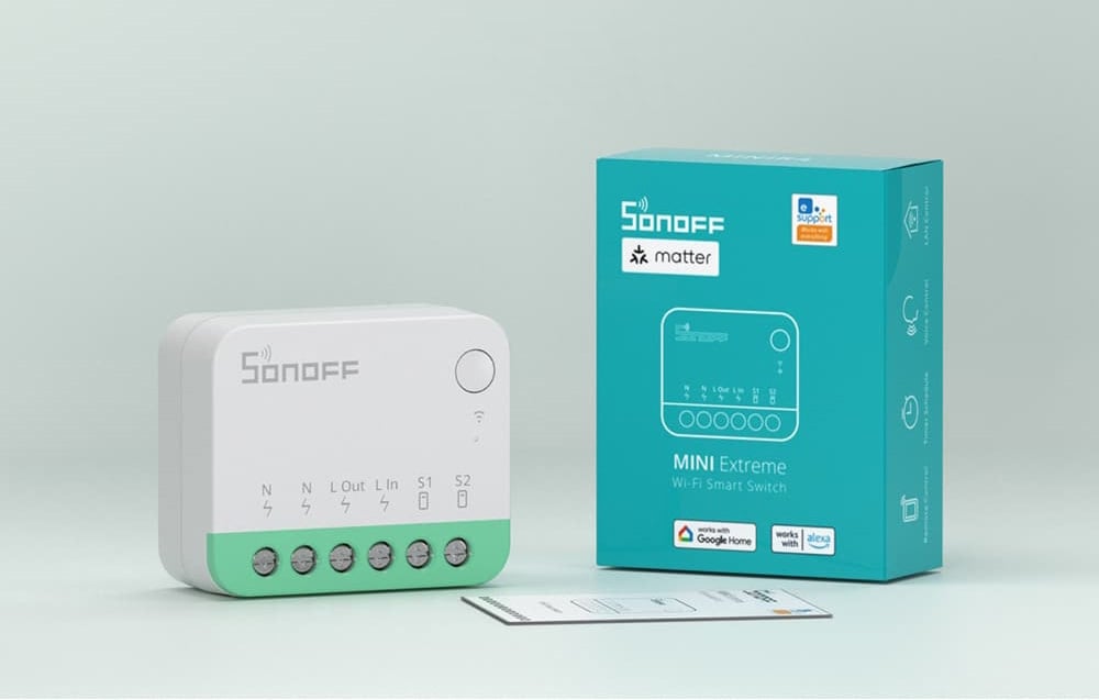 Sonoff switch on the table next to the user manual and packaging