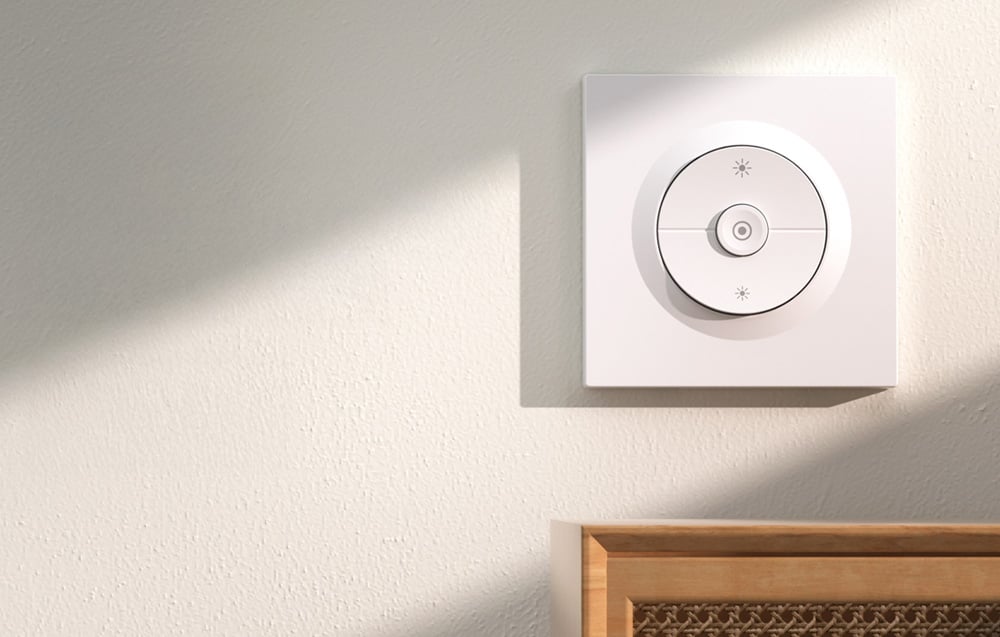 Sonoff wall switch on a light-colored wall with a wooden cabinet underneath