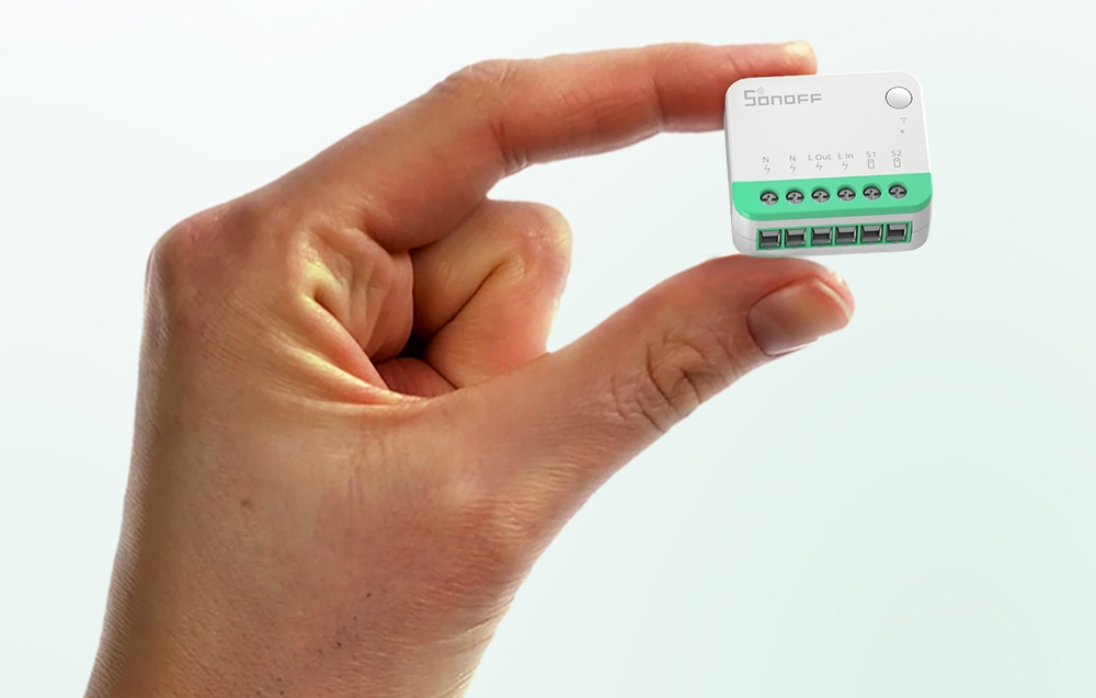 The Sonoff switch held in her hand
