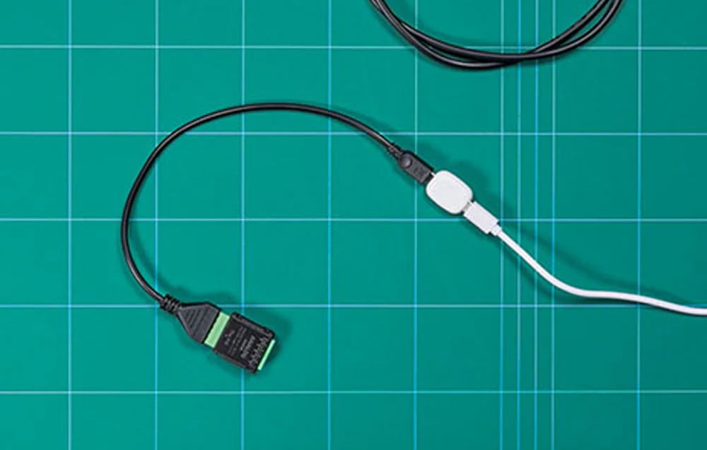 Universal sensor connected to cables lying on a green mat