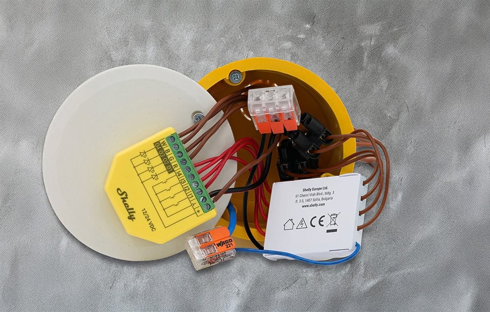 Shelly appliance with multiple wires connected in the electrical box - visible WAGO connectors and module with yellow housing