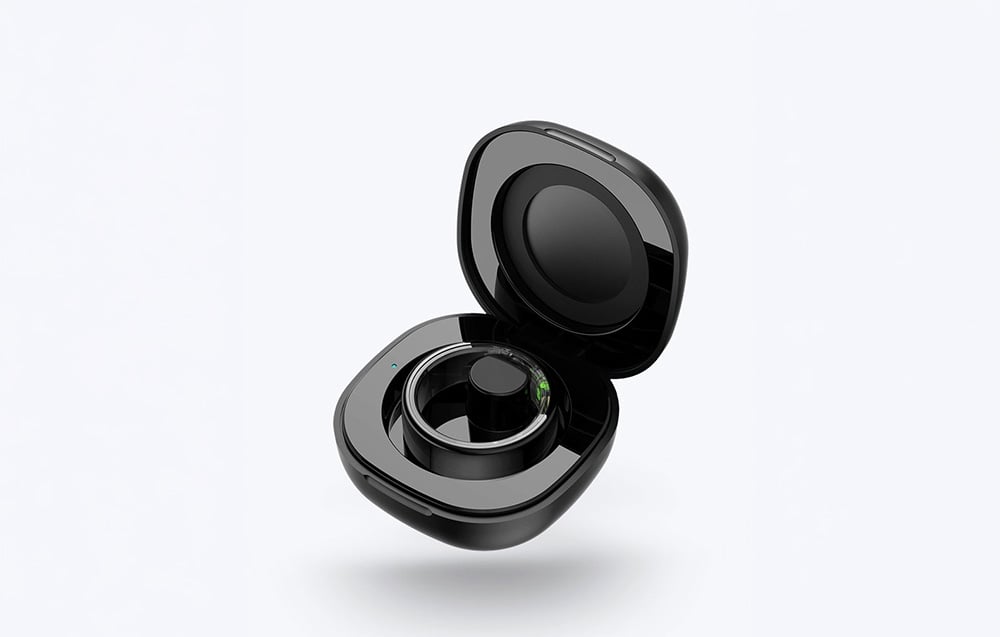 Open black charging case with a black smart ring inside