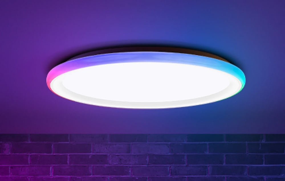 Yeelight Mars C400 ceiling lamp shining white and colored light against a brick wall.