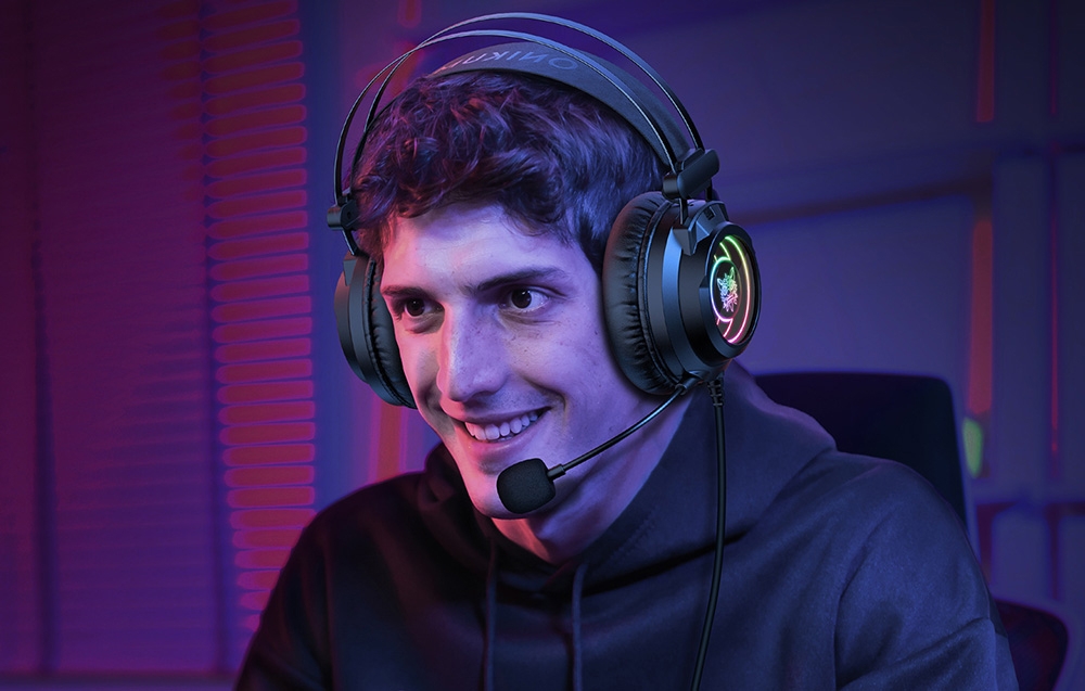 Smiling man in hoodie wearing gaming headphones with microphone