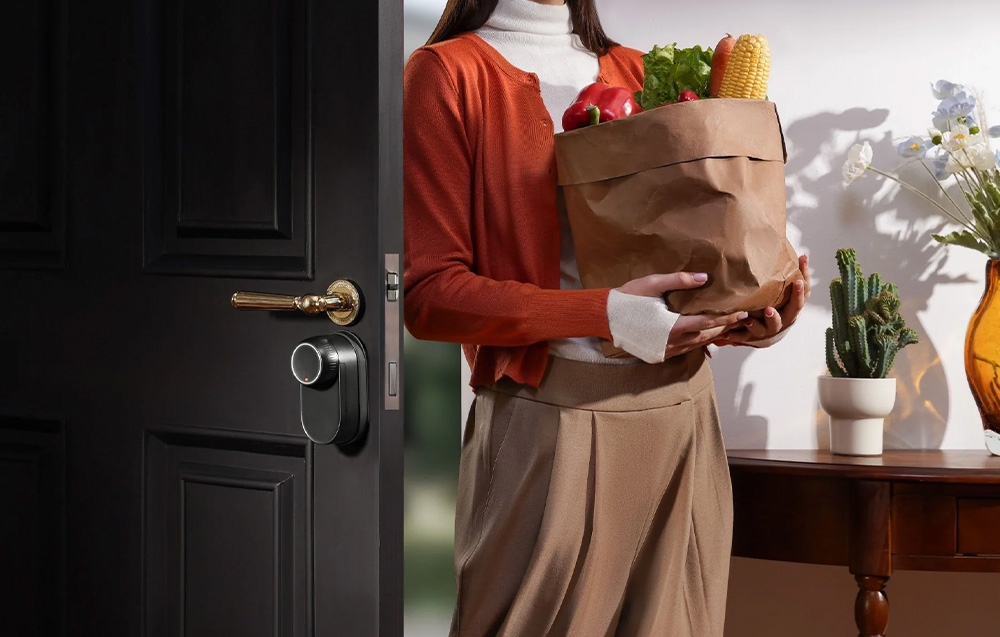 Woman with shopping bag in front of door with SwitchBot electronic lock in bright interior