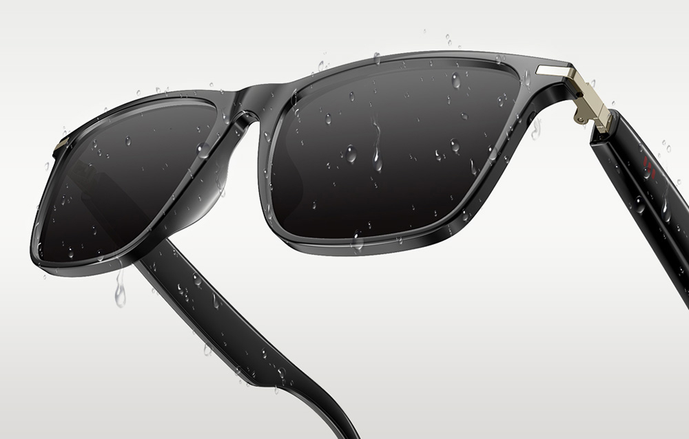 A close-up of black glasses covered in water droplets, highlighting their moisture resistance.