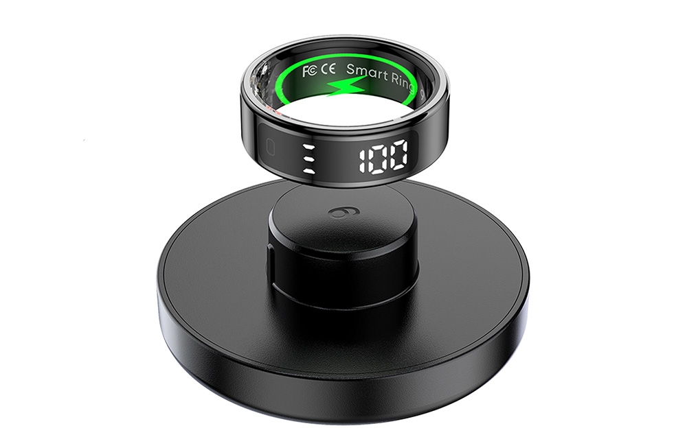 Smartring with display above black charging base.