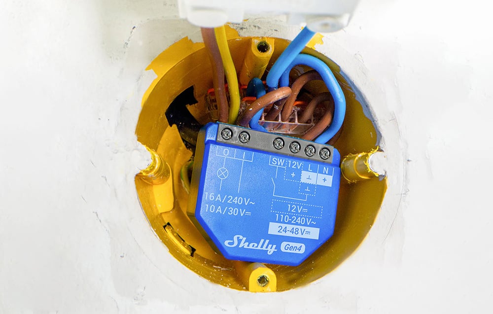 View of the interior of the electrical box with the controller installed, colored wires, and terminal blocks.