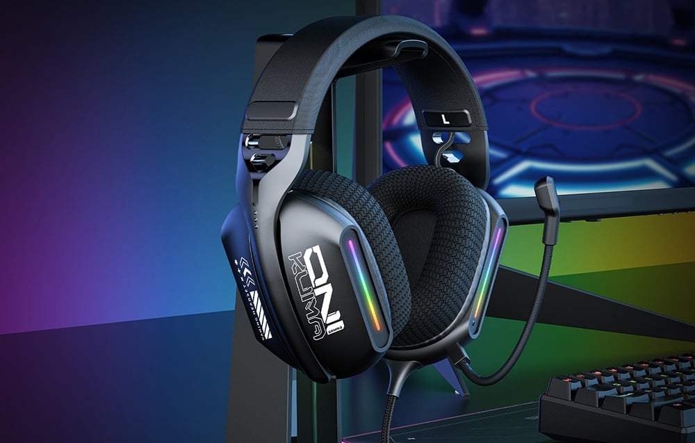 Gaming headphones with backlight on stand next to keyboard and monitor on desk