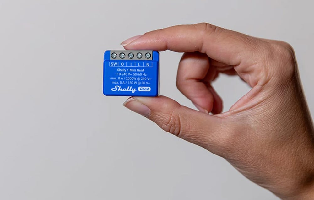 A miniature blue controller held between two fingers.