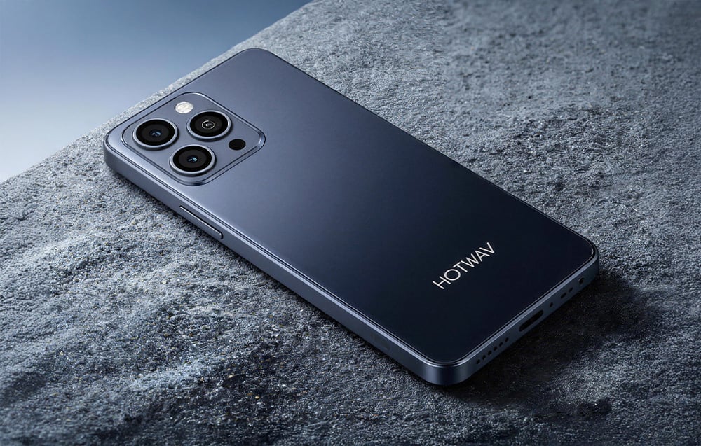 Black Hotwav smartphone lying on a dark rock