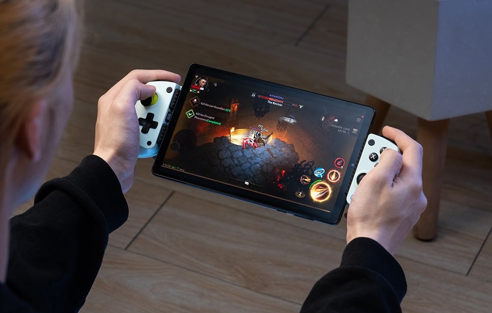 A person playing on a tablet mounted in a GameSir controller with white handles.