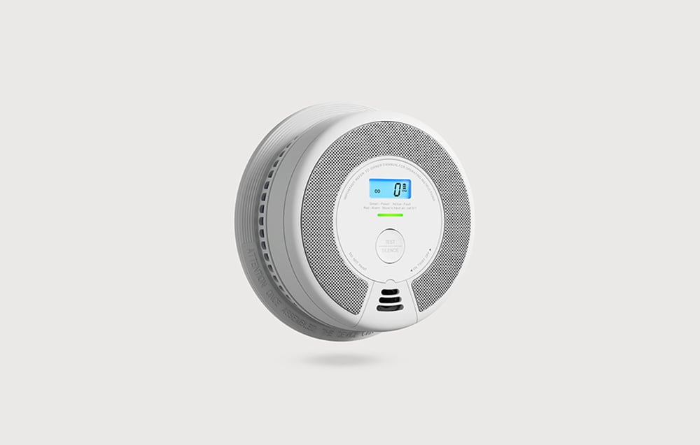 A white, round carbon monoxide detector with an LCD display showing a level of 0 PPM and a Test/Silence button