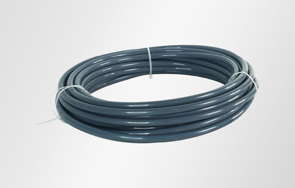 Dark gray, flexible garden hose coiled in a circle and secured with white cable ties
