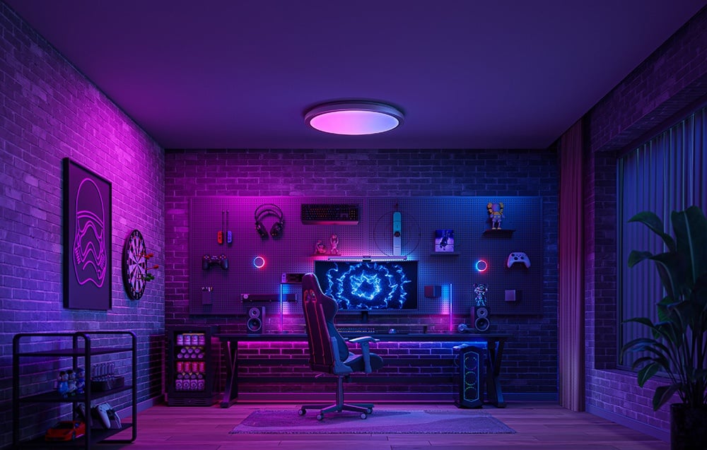 Gaming room with backlighting in purple and pink, with Yeelight Jupiter D C500 lamp over the computer workstation.