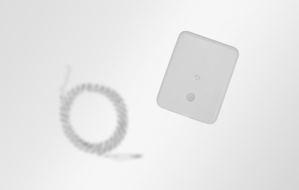 Blurred shot of flooding sensor and cable on white background