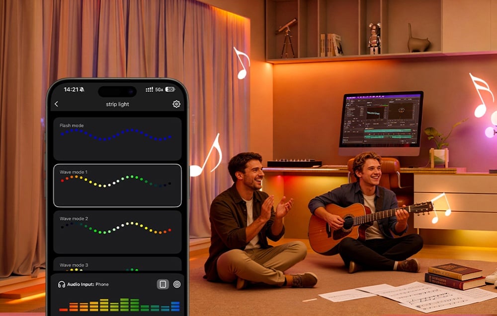 Two men sit on the floor in a room; one of them plays the guitar; the room is lit in colorful lights